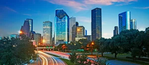 Cảnh đô thị hiện đại về đêm với các cao ốc và tuyến đường nhiều làn xe, minh họa không gian sống đô thị mà thương hiệu Suro hướng tới
